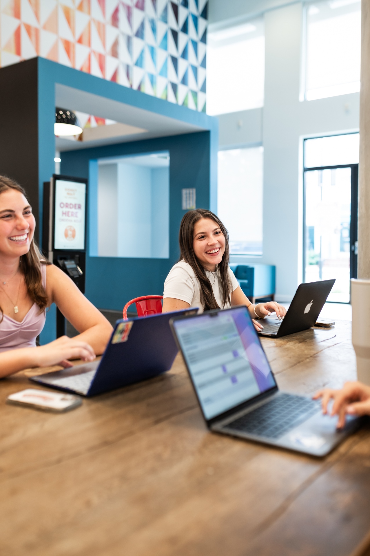 two girls study with their laptops open in study lounge at landmark college park