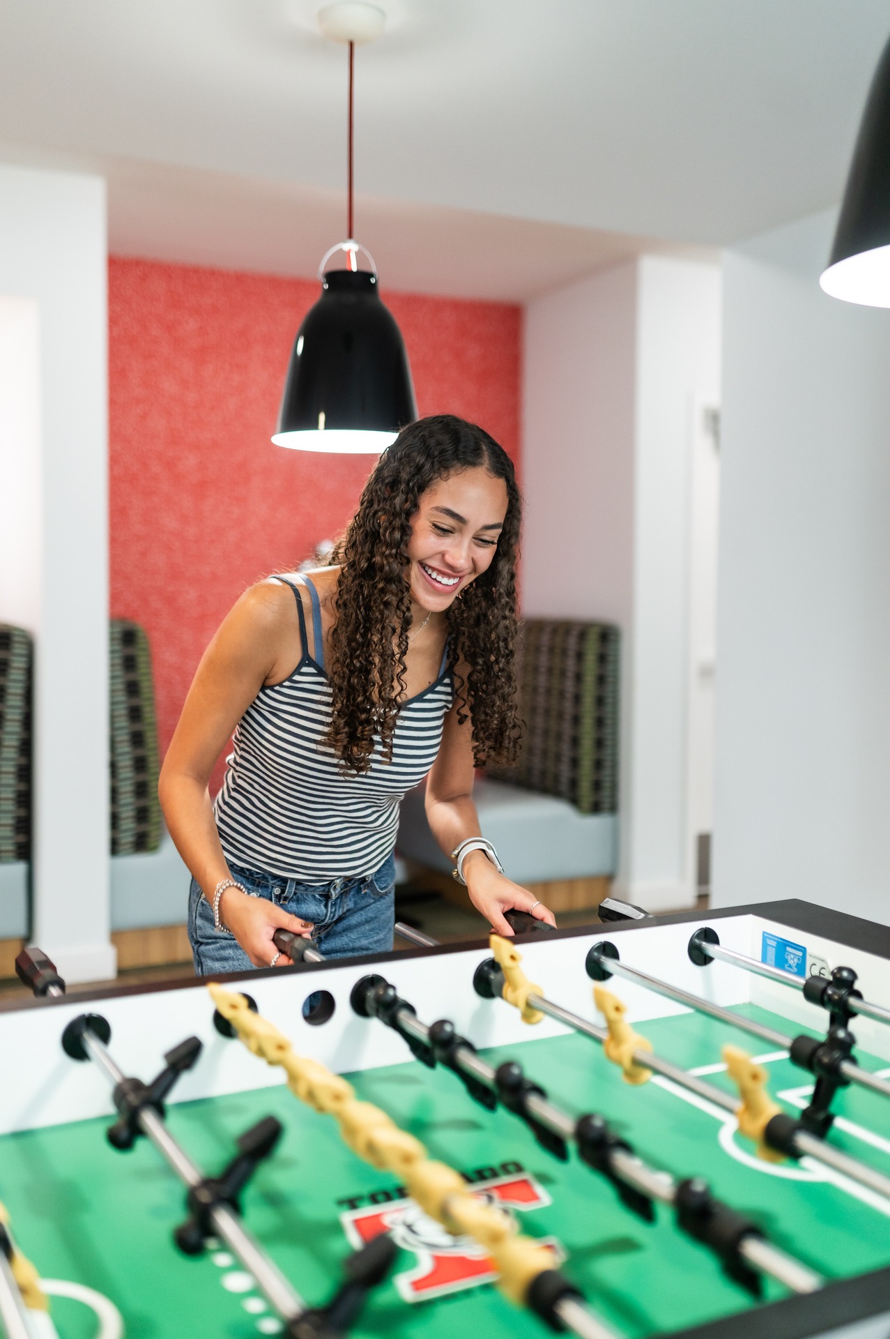 girl playing foosball at landmark college park while smiling