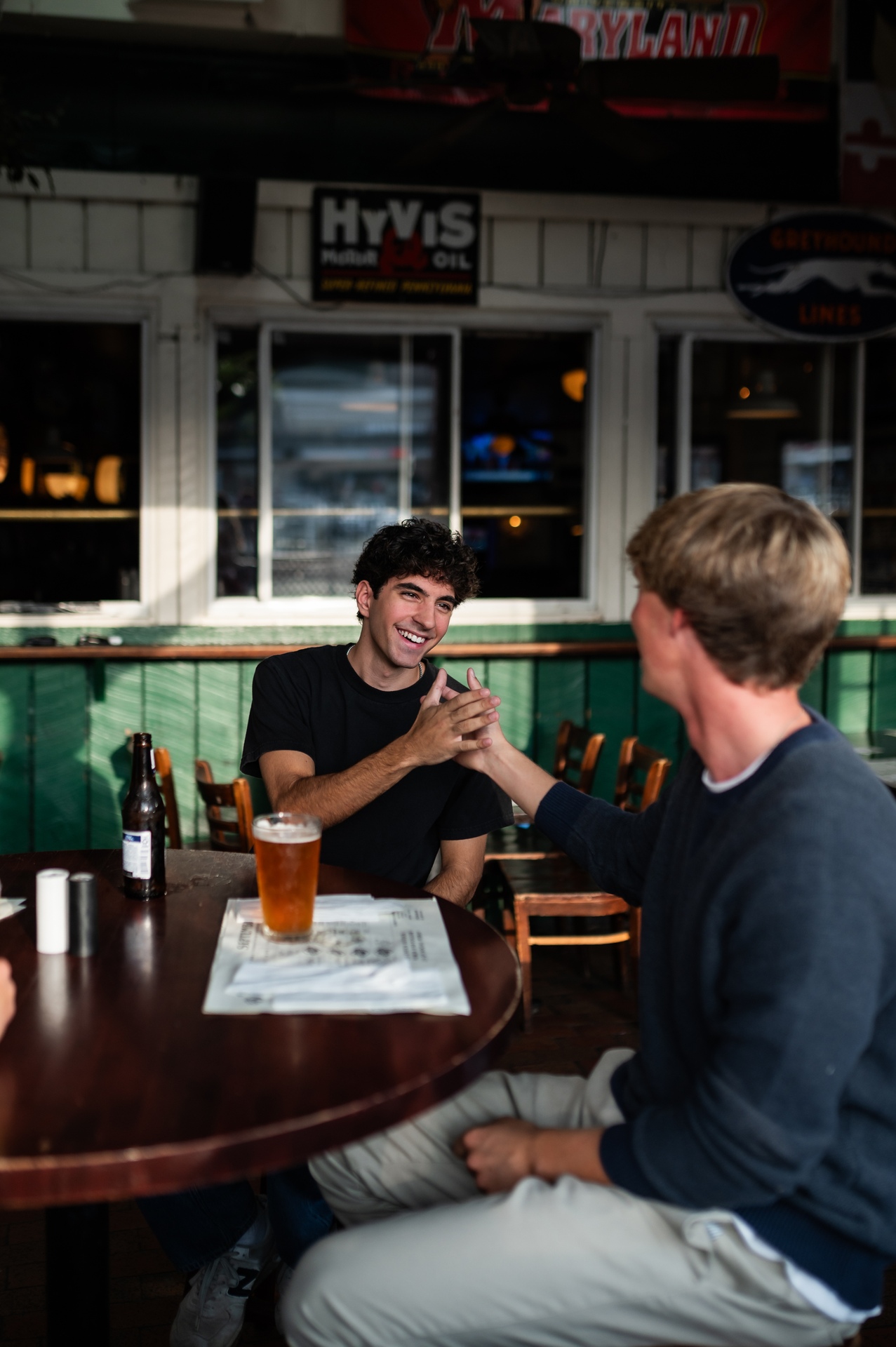 two guys shaking hands in study area on campus landmark college park